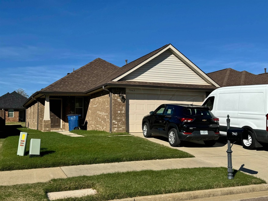 View of side of property featuring a lawn and a ga