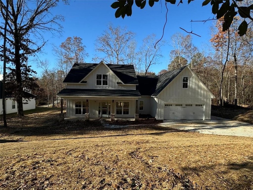 View of front of property with a porch and a garag