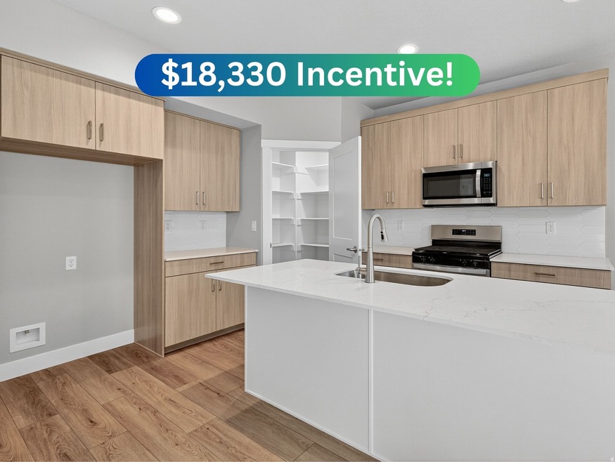 Kitchen with light stone counters, modern cabinets, stainless steel appliances, light wood finished floors, and light brown cabinetry