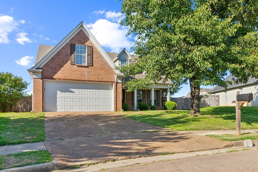 Traditional-style house with brick siding, concrete driveway, and an attached garage