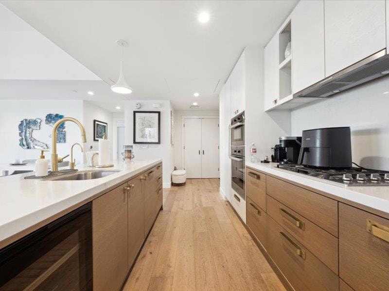 Kitchen with a sink, light countertops, white cab