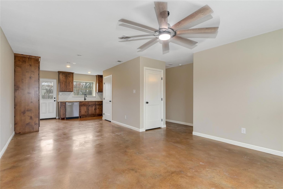 Unfurnished living room with ceiling fan, sink, an