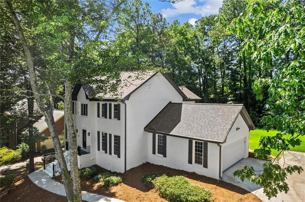 View of property exterior with a shingled roof, concrete driveway, and a garage