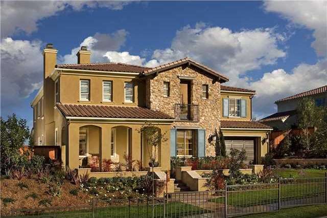 Beautifully landscaped with colored concrete walkways and covered front porch, stucco and stone retaining walls with lighting at steps, stucco covered retaining walls with stone caps.  Landscaping has matured since this picture was taken.