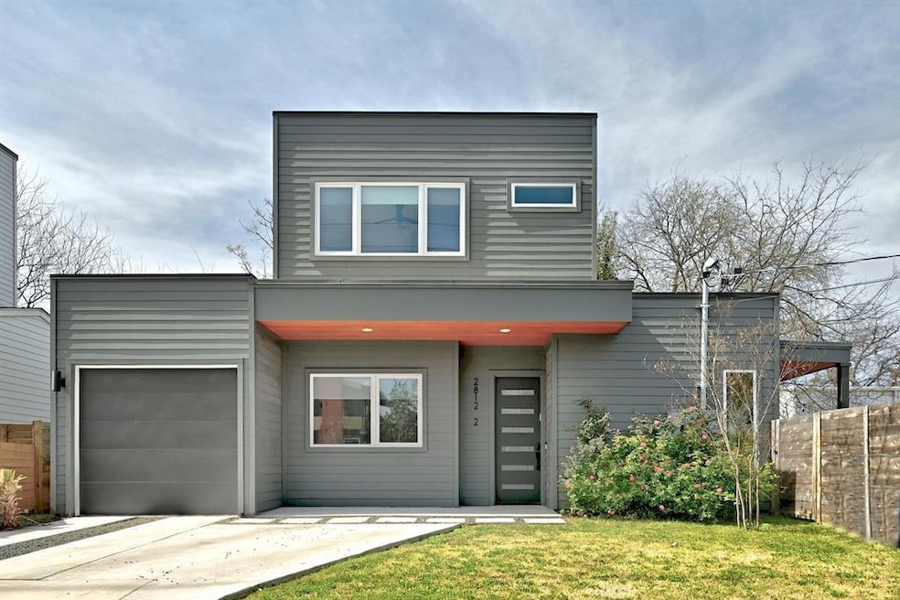 Modern home featuring a garage, concrete driveway