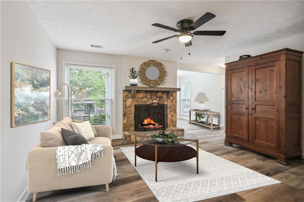 Living room featuring a textured ceiling, a firepl