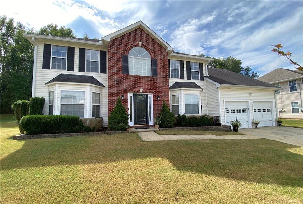 Colonial home with a garage and a front lawn