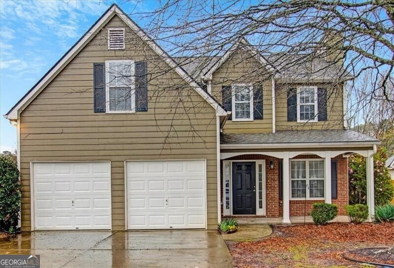 Traditional home with brick siding, a shingled roo