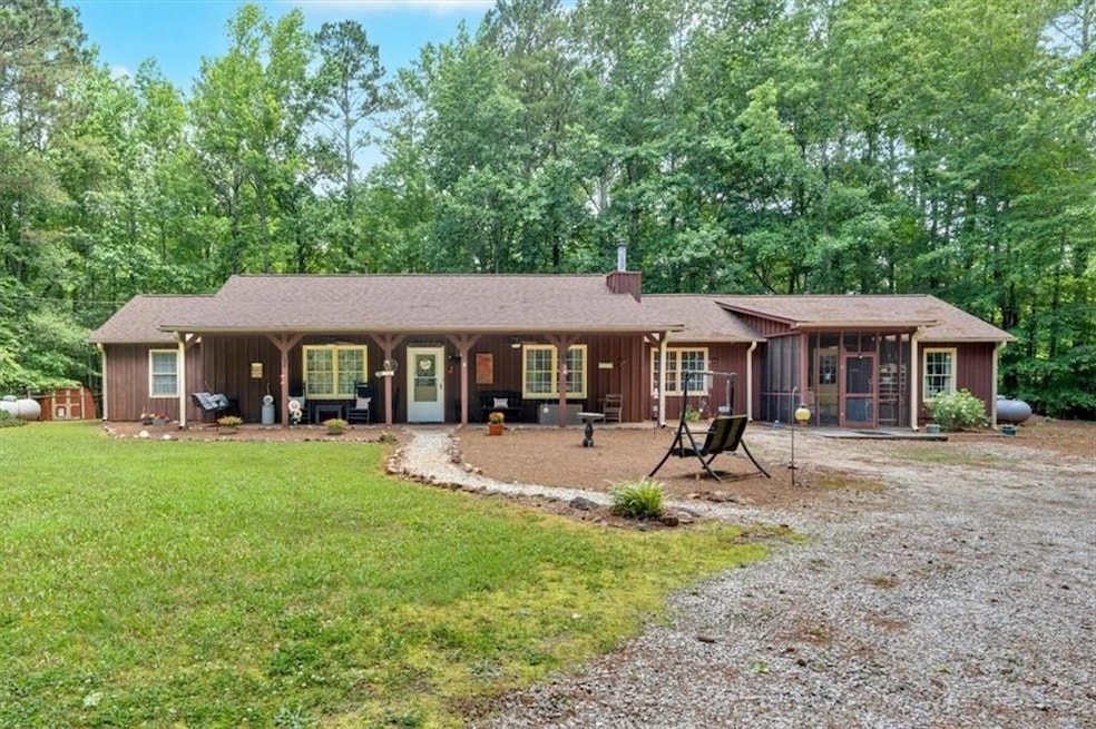 Single story home featuring a sunroom, a front yard, and board and batten siding