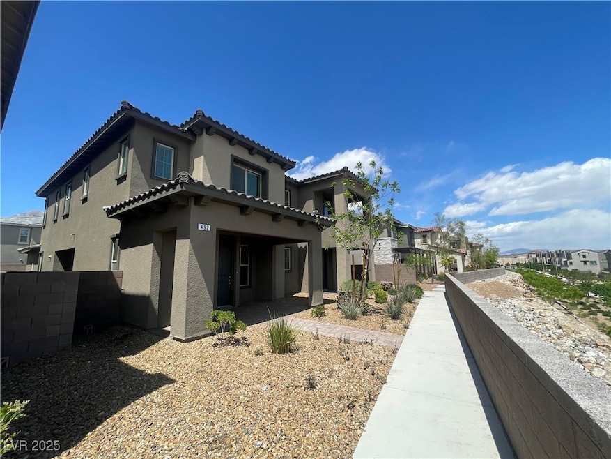 Back of property featuring fence, a tiled roof, an