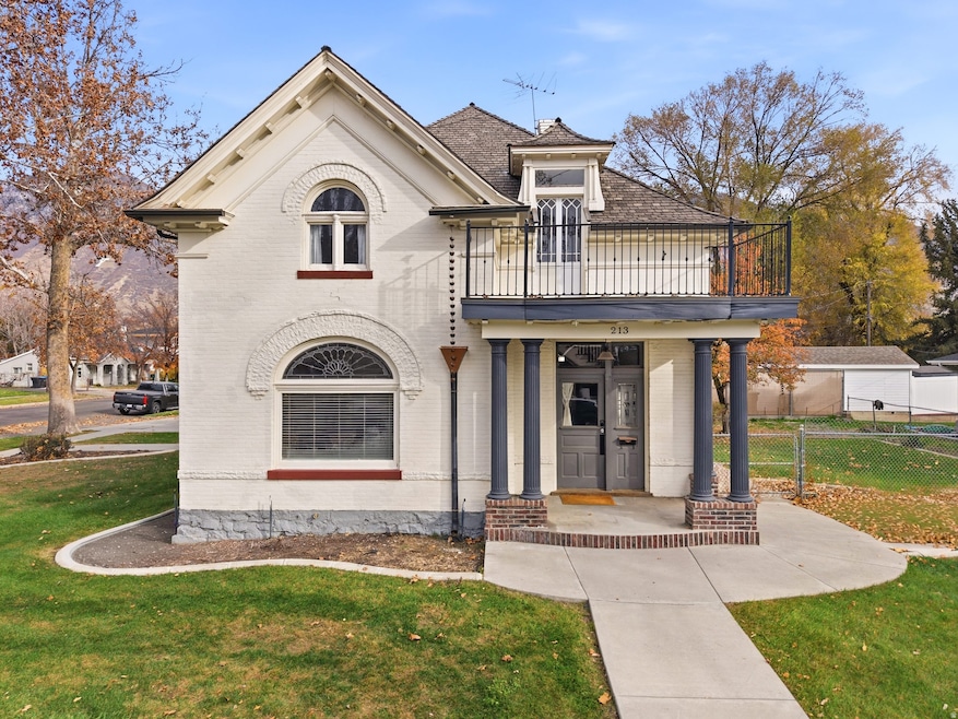 View of front facade featuring brick siding, a porch, and a balcony