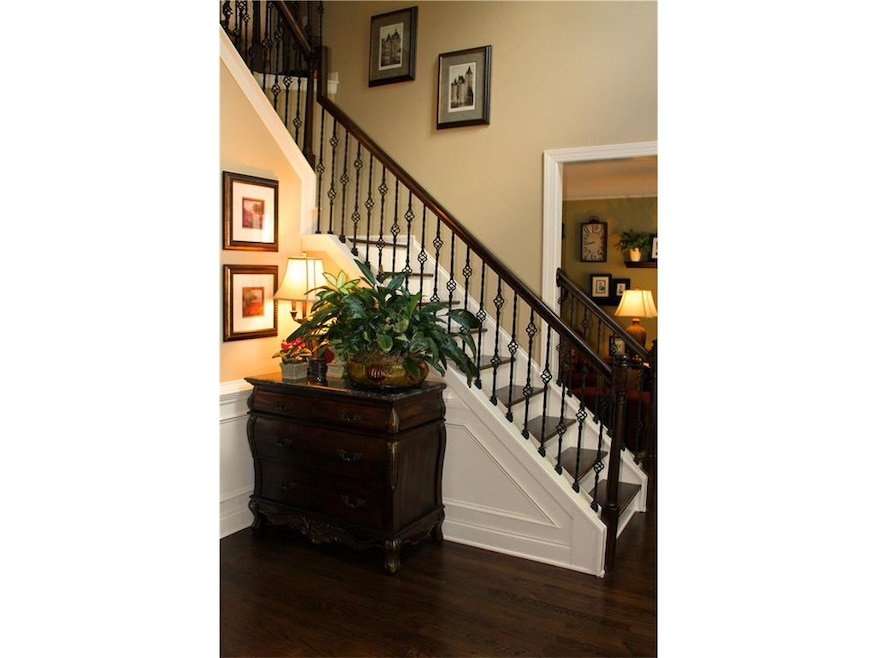Two-story entry foyer with iron railing and beautiful hardwood floors on both levels!