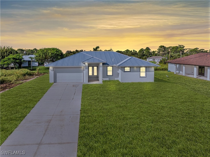 View of front of house featuring a yard and a gara