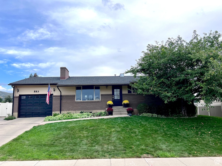 Ranch-style house featuring a chimney, brick siding, a garage, concrete driveway, and a shingled roof