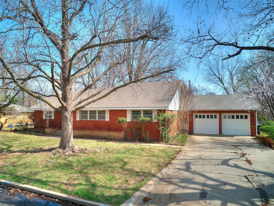 Single story home featuring a front lawn and a gar