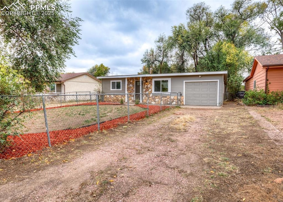 Single story home featuring dirt driveway and stone siding