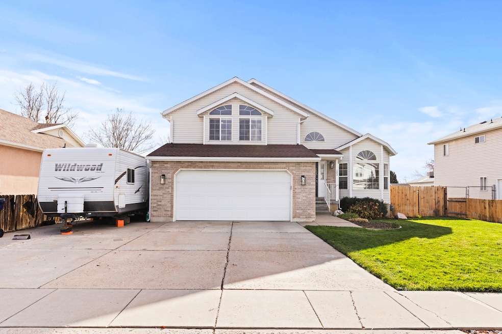 Traditional-style home featuring driveway, brick siding, an attached garage, and a shingled roof