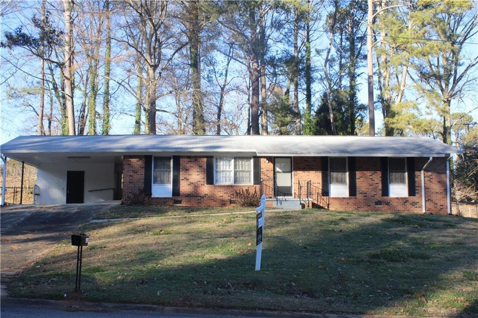 Single story home with a front yard and a carport