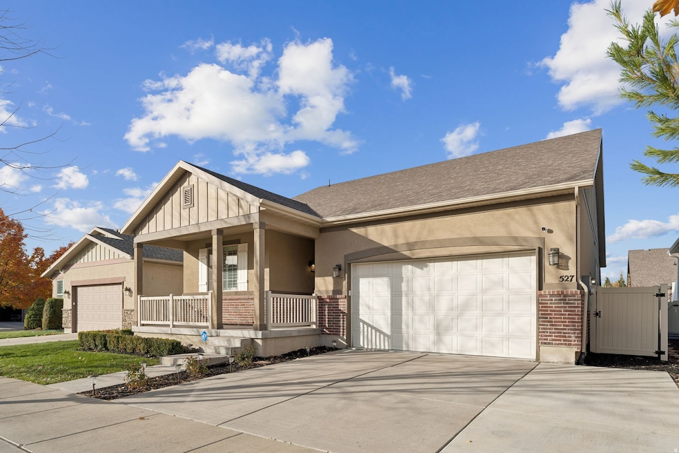 View of front of property featuring brick siding, a porch, a gate, concrete driveway, and a garage