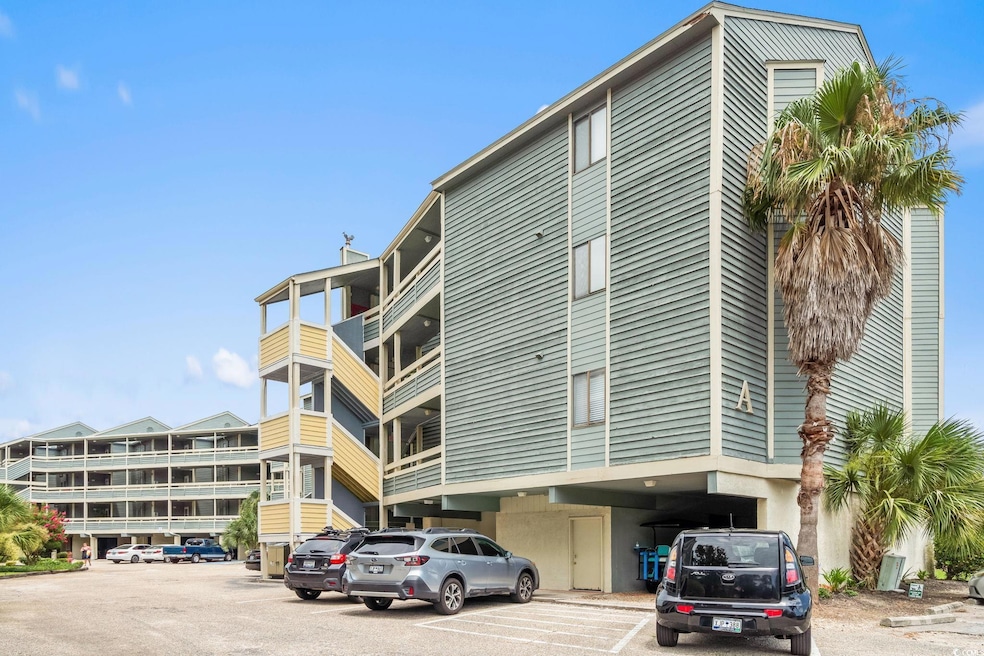View of apartment building / complex with uncovered parking