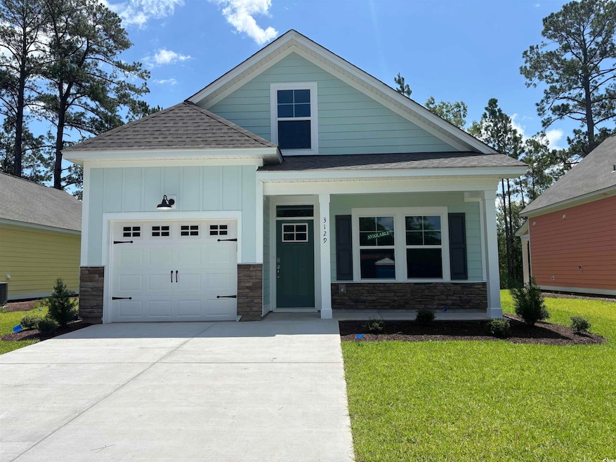 View of front of house featuring a garage, stone siding, a shingled roof, a front yard, and driveway