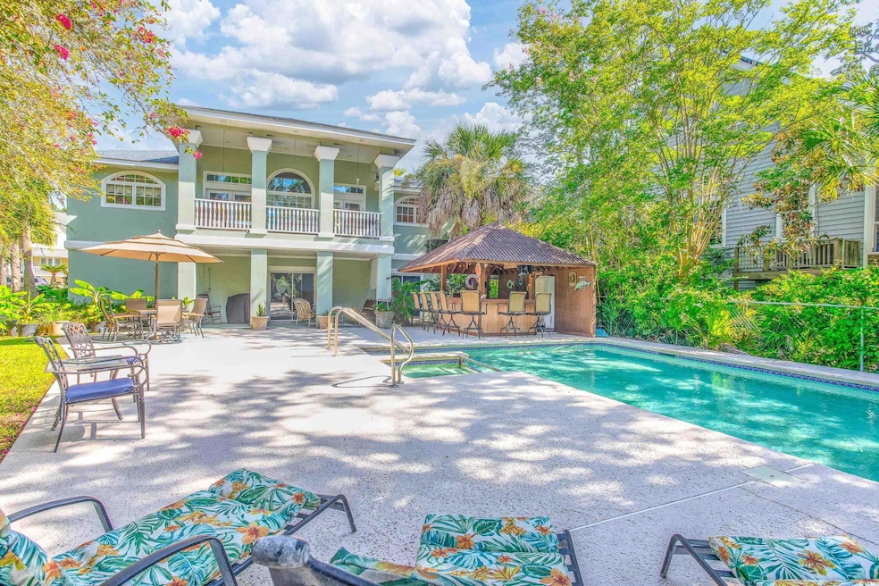 View of pool with a patio area and a pool with connected hot tub