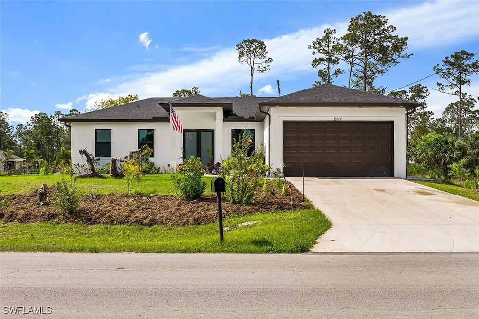 View of front of property featuring a garage, driv
