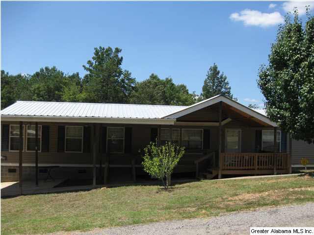 Large home with a metal roof & covered front porch.