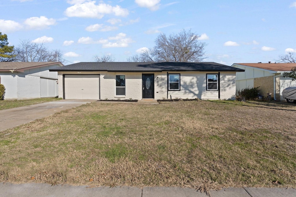 Single story home featuring a front yard and a gar