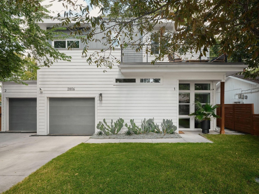 Rear view of house with an attached garage, a yard, and driveway
