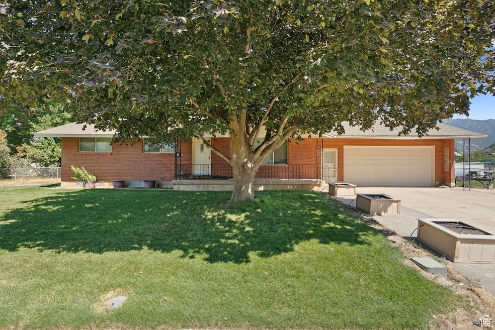 View of front of property with brick siding, concrete driveway, and a garage