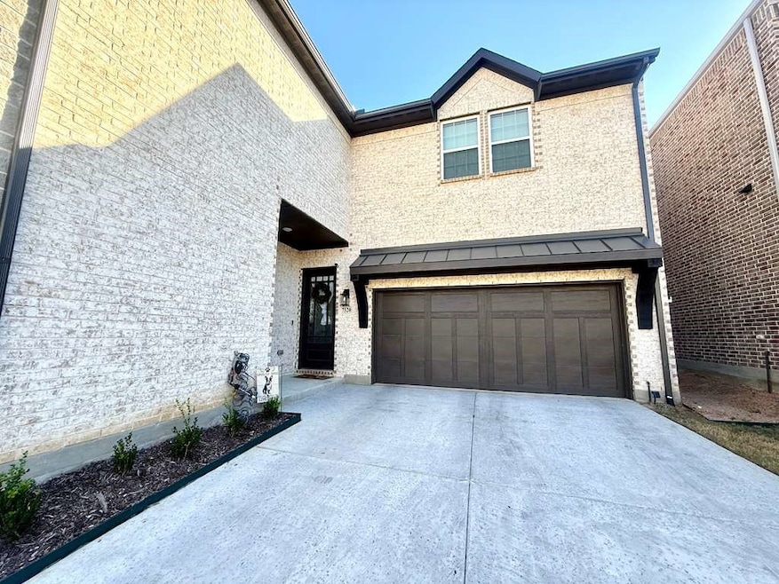 View of front of home with concrete driveway and an attached garage