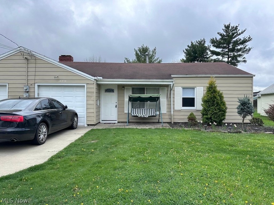 Single story home with a garage and a front yard