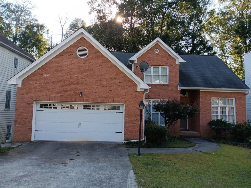 View of property featuring a garage and a yard