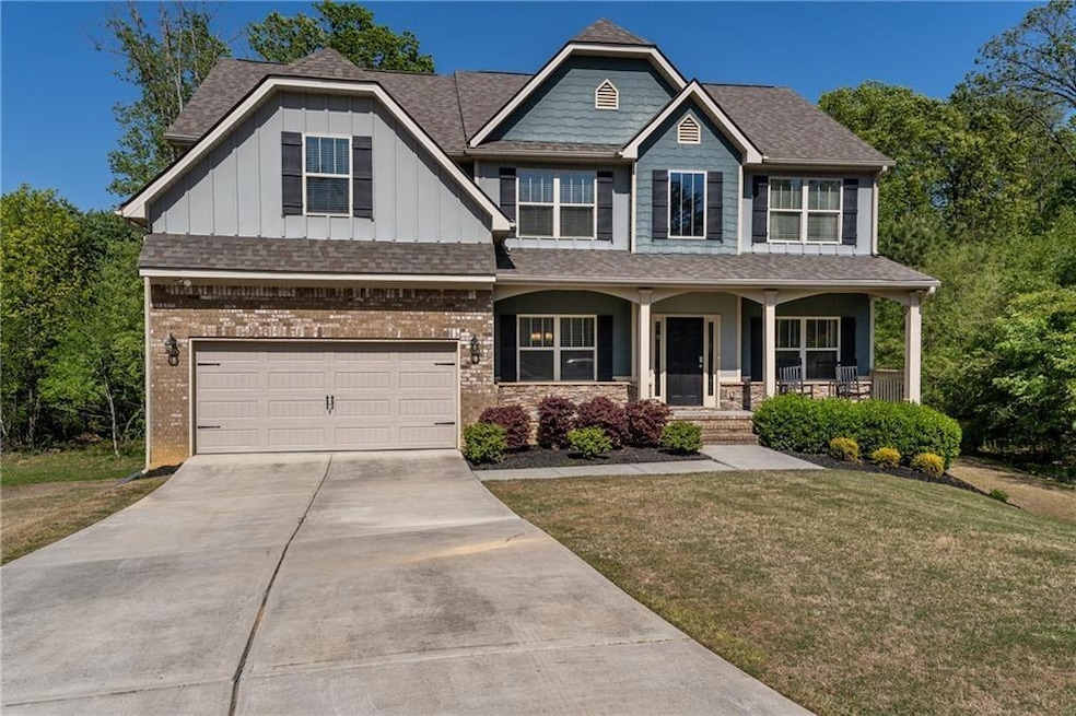 Craftsman inspired home with board and batten siding, a porch, roof with shingles, and concrete driveway