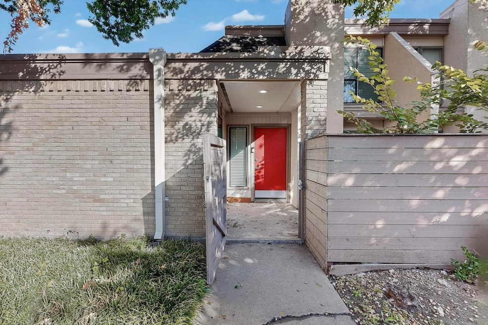 Doorway to property featuring brick siding and stucco siding