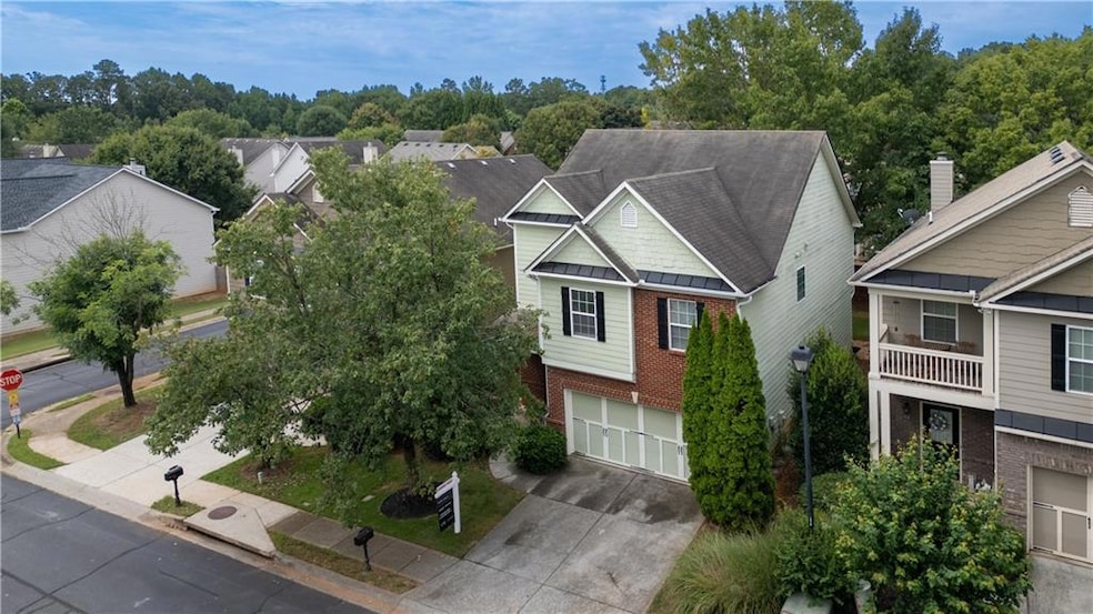 View of front of home featuring brick siding, a residential view, a standing seam roof, concrete driveway, and a garage