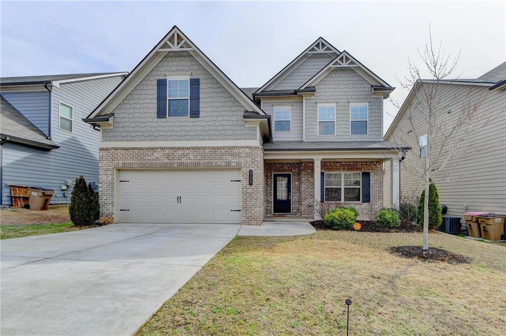 Craftsman-style home featuring a front lawn, a gar