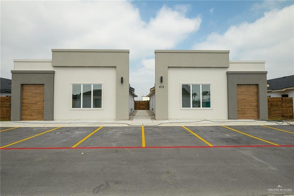 View of building exterior featuring uncovered parking