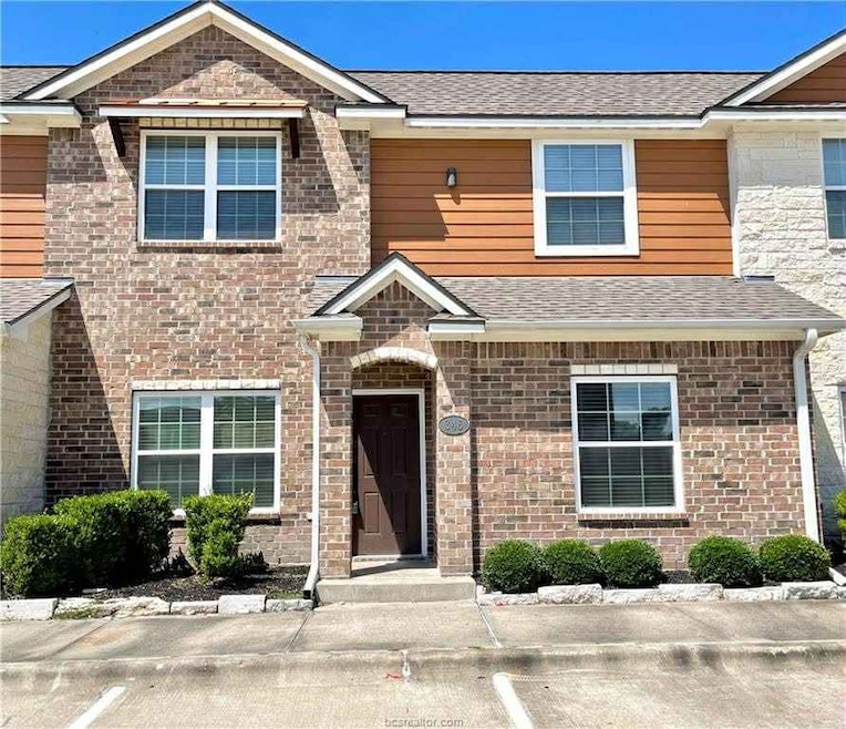 View of front of house with uncovered parking and roof with shingles
