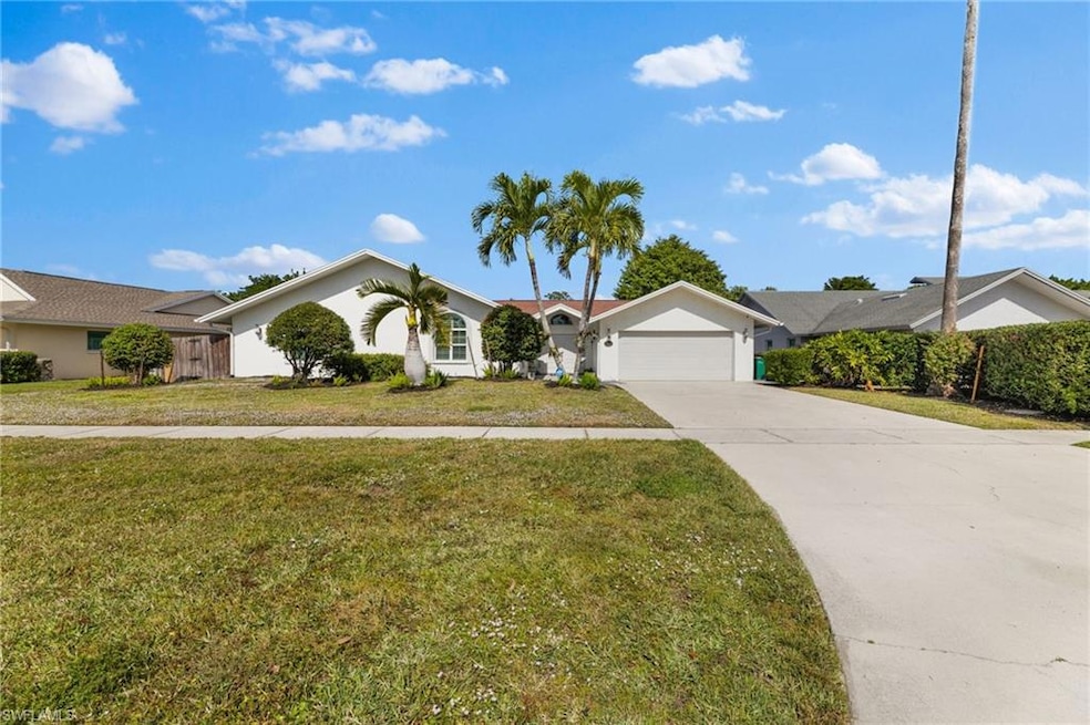 Ranch-style home featuring a front yard and a gara