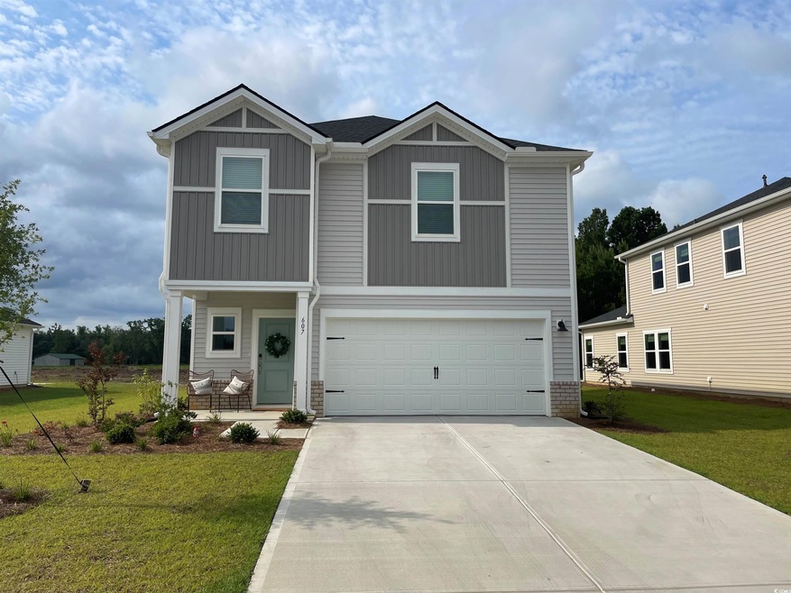 View of front of home with a garage and a front ya