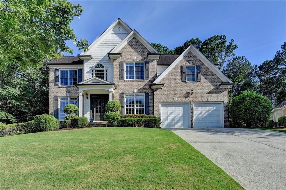 View of front of home with driveway, brick siding, a front lawn, and an attached garage