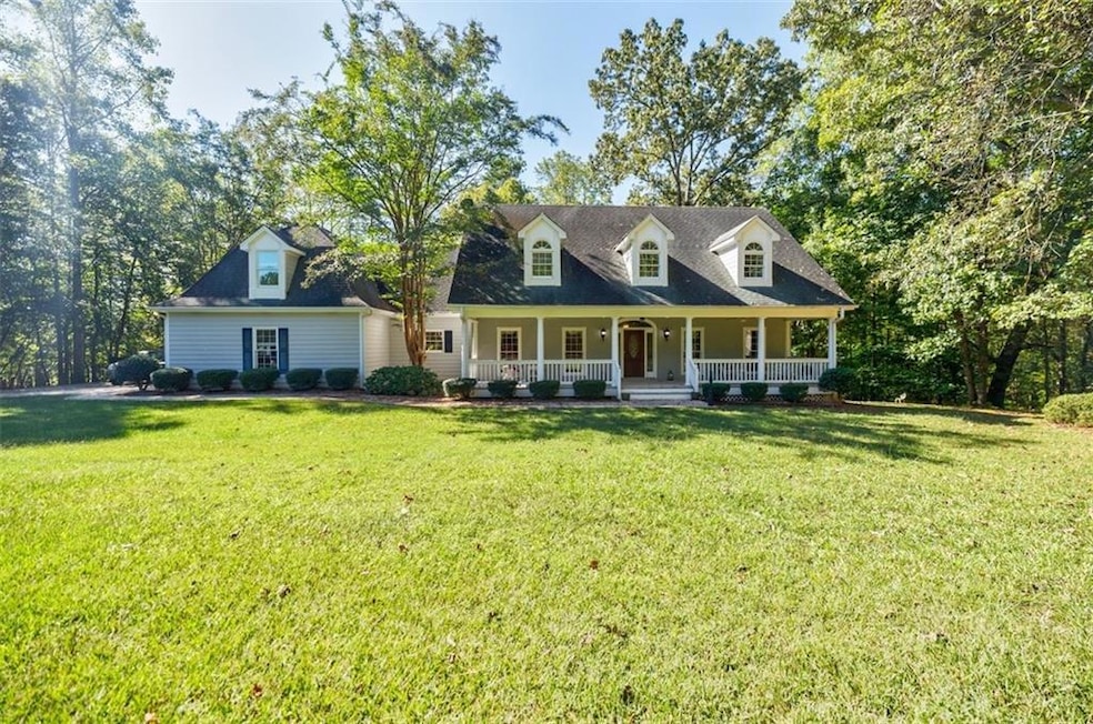 Cape cod home with a front yard and a porch