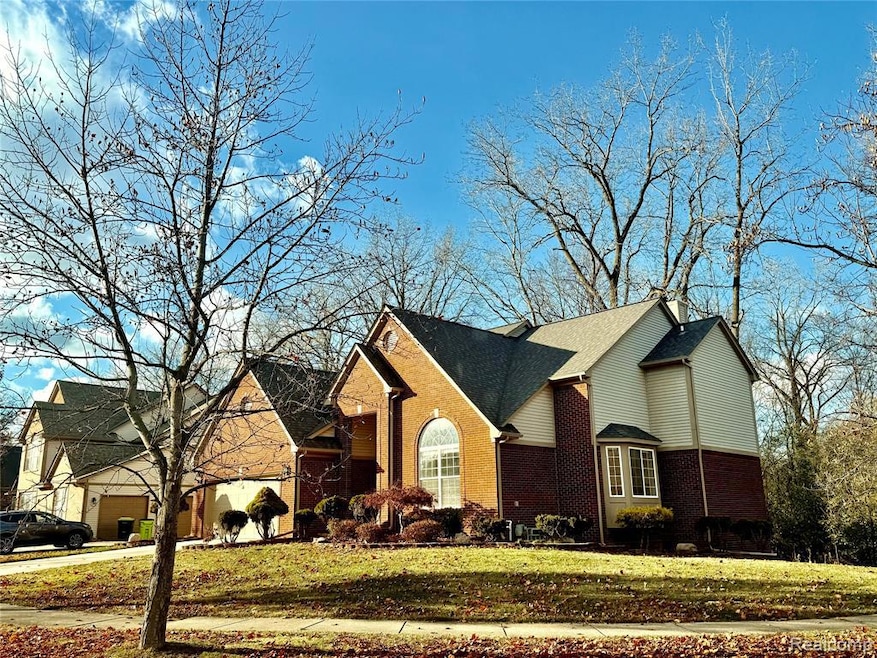 View of front facade featuring brick siding, a front lawn, and roof with shingles