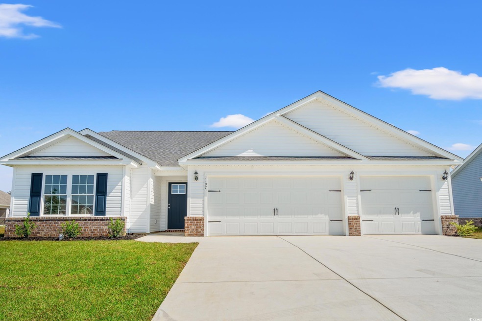 View of front of property featuring a front yard, concrete driveway, a garage, brick siding, and roof with shingles