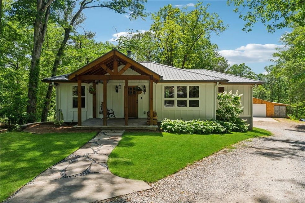 View of front of property featuring board and batten siding, a porch, driveway, and a front lawn