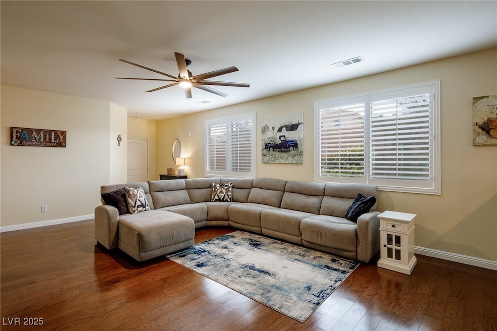 Living area with ceiling fan, wood finished floors