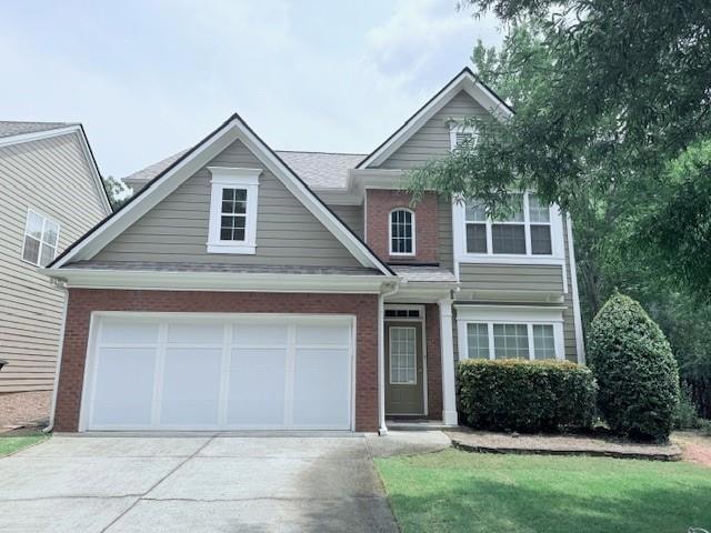 Traditional home with brick siding, concrete driveway, and an attached garage