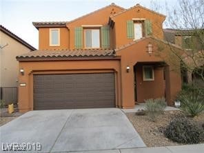 Mediterranean / spanish-style house featuring a ga